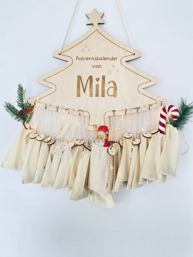 Adventskalender-Tannenbaum Ein hölzernes Schild in Form eines Weihnachtsbaums mit dem Namen Mila und Geschenktüten.